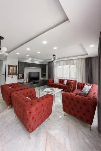 un soggiorno con divani rossi e camino di ŞAHNAZ VİLLA Suits a Belek Altre 73 foto