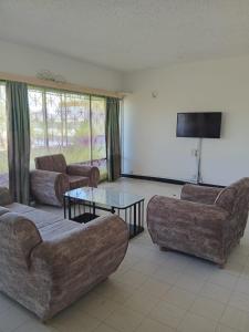 a living room with two couches and a tv at Kibaki Ocean Front Residence 18 in Mombasa