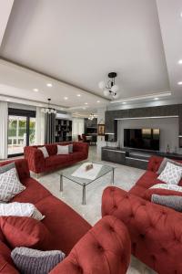 un ampio soggiorno con divani rossi e tavolo di ŞAHNAZ VİLLA Suits a Belek