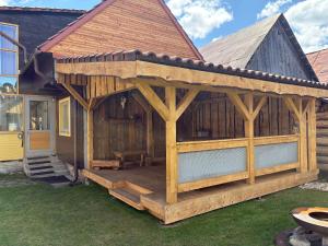 un grande pergolato in legno attaccato a una casa di Chata Pod Úbočou a Liptovská Teplička