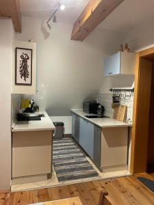 una piccola cucina con ripiani bianchi e un piano di lavoro di Chata Pod Úbočou a Liptovská Teplička Altre 2 foto