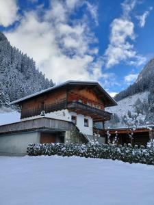 a building with snow on the ground in front of it at Apartment Wandegg im Bergsteigerdorf Ginzling Mayrhofen in Mayrhofen
