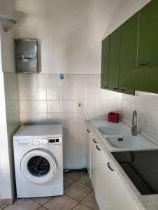 eine kleine Küche mit einer Waschmaschine und einem Waschbecken in der Unterkunft La petite étoile in Aosta