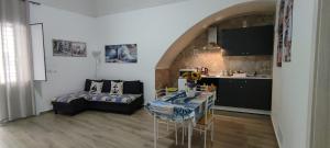 a living room with a table and a kitchen at Sky Blue Marine in Catania