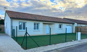 ein Haus mit einem Zaun davor in der Unterkunft Maison cosy avec SPA - Logis Flo - à 15 min du Futuroscope in Beaumont
