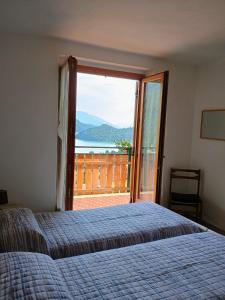 a bedroom with a bed and a large window at Villa Primula in Molveno