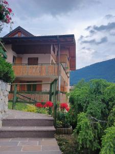 a house with a balcony and red flowers in front of it at Villa Primula in Molveno