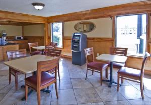 un restaurante con mesas, sillas y nevera en Sweet Dream Inn en Pensacola
