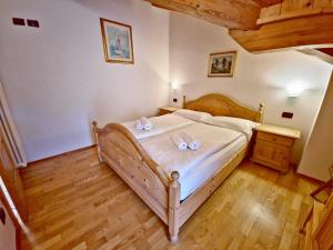 1 dormitorio con 1 cama con sábanas blancas y arcos en Villetta Clara by AMA Val di Fassa, en Vigo di Fassa