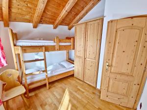 Una habitación con dos literas y una puerta. en Villetta Clara by AMA Val di Fassa, en Vigo di Fassa