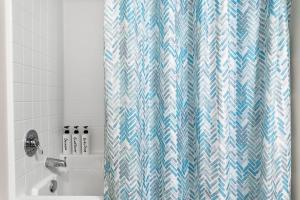 a bathroom with a blue and white shower curtain at Modern Room Nested In The Heart Of Orange County in Tustin +15 photos