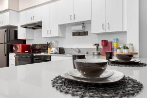 a kitchen with white cabinets and a bowl on a counter at Modern Room Nested In The Heart Of Orange County in Tustin
