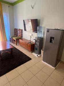sala de estar con nevera y mesa en Jerres Inn, en Mtwapa
