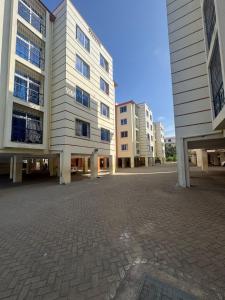 un estacionamiento vacío frente a algunos edificios en Jerres Inn, en Mtwapa