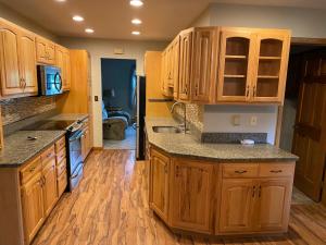 a kitchen with wooden cabinets and wooden floors at 2 bedroom home in a quiet neighborhood in Plattsburgh