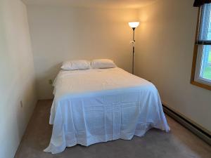 a bedroom with a bed with a white bedspread at 2 bedroom home in a quiet neighborhood in Plattsburgh