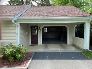 a home with a garage with a red roof at 2 bedroom home in a quiet neighborhood in Plattsburgh