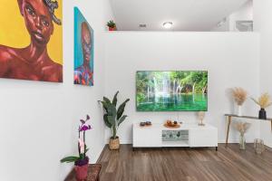 uma sala de estar com uma televisão de ecrã plano numa parede branca em Spacious Place 8 Mins To Disneyland *FREE Parking* em Tustin