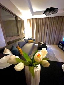 a living room with a couch and a vase with flowers at Luxury Studio in a secured residence in Aïn Harrouda