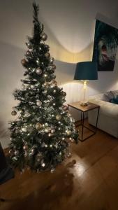 a christmas tree in a living room with a lamp at ROYAL WILLIAM YARD Luxury Apartments at "THE BRUCE" - FAMILY APARTMENT and Connecting DELUXE STUDIO - PRIVATE connecting lobby so BOOK BOTH For LARGER GROUPS - FREE ONSITE PARKING in Plymouth