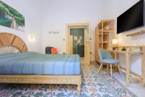 a bedroom with a bed and a desk and a television at Vintage Rooms in Palermo