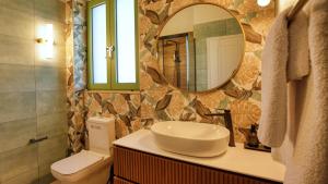 a bathroom with a sink and a toilet and a mirror at Alkyoni luxury apartments Katakolo in Katakolon +98 photos