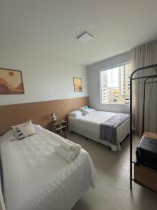 a hotel room with two beds and a window at 1101 Barra Salvador - Excelente para o Carnaval! in Salvador
