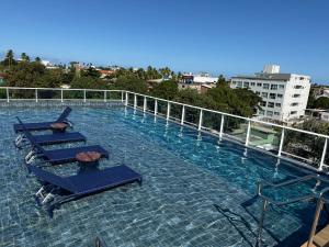 una piscina con tumbonas en un edificio en Harbor Living by AFT - Porto de Galinhas, en Porto de Galinhas