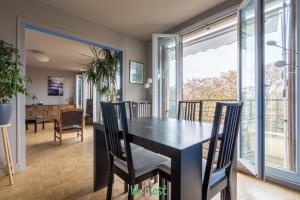 une salle à manger avec une table et des chaises noires dans l'établissement IDF - HUGO - CI - Séjour cosy aux portes de Paris, à Maisons-Alfort