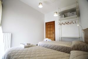 two beds in a room with white walls at Casa Camilla in Monopoli