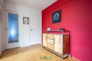 une pièce avec un mur rouge et une armoire en bois dans l'établissement IDF - HUGO - CI - Séjour cosy aux portes de Paris, à Maisons-Alfort