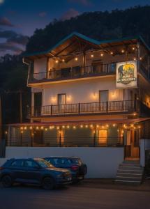 ナイニタールにあるThe Aura by Backpackers Stopの灯台付きの建物の前に停められた車両2台