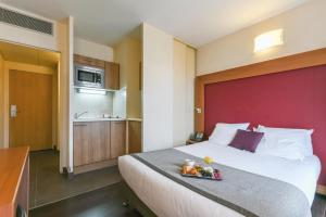 a hotel room with a bed with a tray of food on it at Appart'City Collection Paris Grande Bibliothèque in Paris