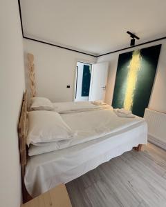 a bedroom with two beds and a large window at Cabana Gala Doftanei in Trăisteni +26 photos