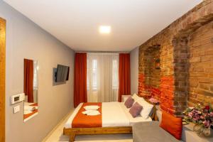 a bedroom with a bed and a brick wall at Lion Apart Hotel Taksim in Istanbul