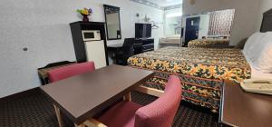 Turnpike Motel Richmond VA by Hotel O US 60 في ريتشموند: غرفة فندقية تحتوي على سريرين وطاولة وكراسي