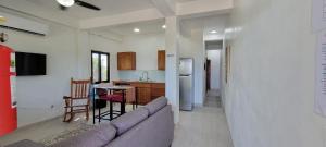 a living room with a couch and a kitchen at Lickety Split 2 - Northside, Oceanview Retreat in Caye Caulker