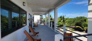 a balcony with chairs and a view of the ocean at Lickety Split 2 - Northside, Oceanview Retreat in Caye Caulker