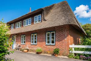 a brick house with a thatched roof at Gabrielswarft in Dagebüll