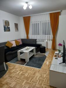 a living room with a couch and a table at SM apartman in Bijeljina