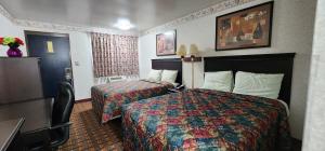 Turnpike Motel Richmond VA by Hotel O US 60 في ريتشموند: غرفة فندق بها سريران ومكتب