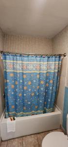 Turnpike Motel Richmond VA by Hotel O US 60 في ريتشموند: حمام مع ستارة دش زرقاء على حوض الاستحمام +41 صورة