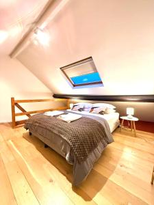 ein Schlafzimmer mit einem großen Bett mit Dachfenster in der Unterkunft European Lodge Duplex in Brüssel