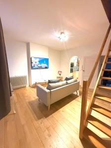 ein Wohnzimmer mit einer Couch und einer Treppe in der Unterkunft European Lodge Duplex in Brüssel