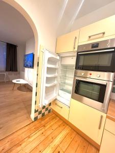 eine Küche mit einem Backofen und einem offenen Kühlschrank in der Unterkunft European Lodge Duplex in Brüssel