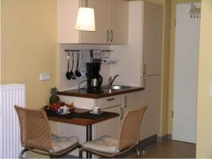 a kitchen with a table and chairs in a kitchen at Ferienhaus im skandinavischen Stil in Granzow +24 photos