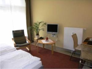 a bedroom with a bed and a desk with a computer at Ferienhaus im skandinavischen Stil in Granzow