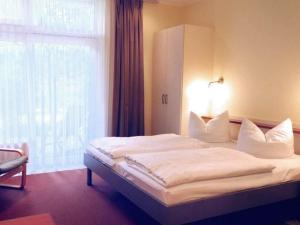 a bedroom with a white bed with a window at Elegant eingerichtete Ferienwohnung in Granzow +24 photos