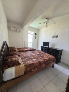 a bedroom with two beds and a desk in it at Bahía 50's in Acapulco +26 photos
