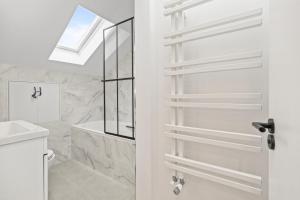 a bathroom with a shower and a toilet and a window at Luxury modern 1 bed between Hampstead and Camden in London
